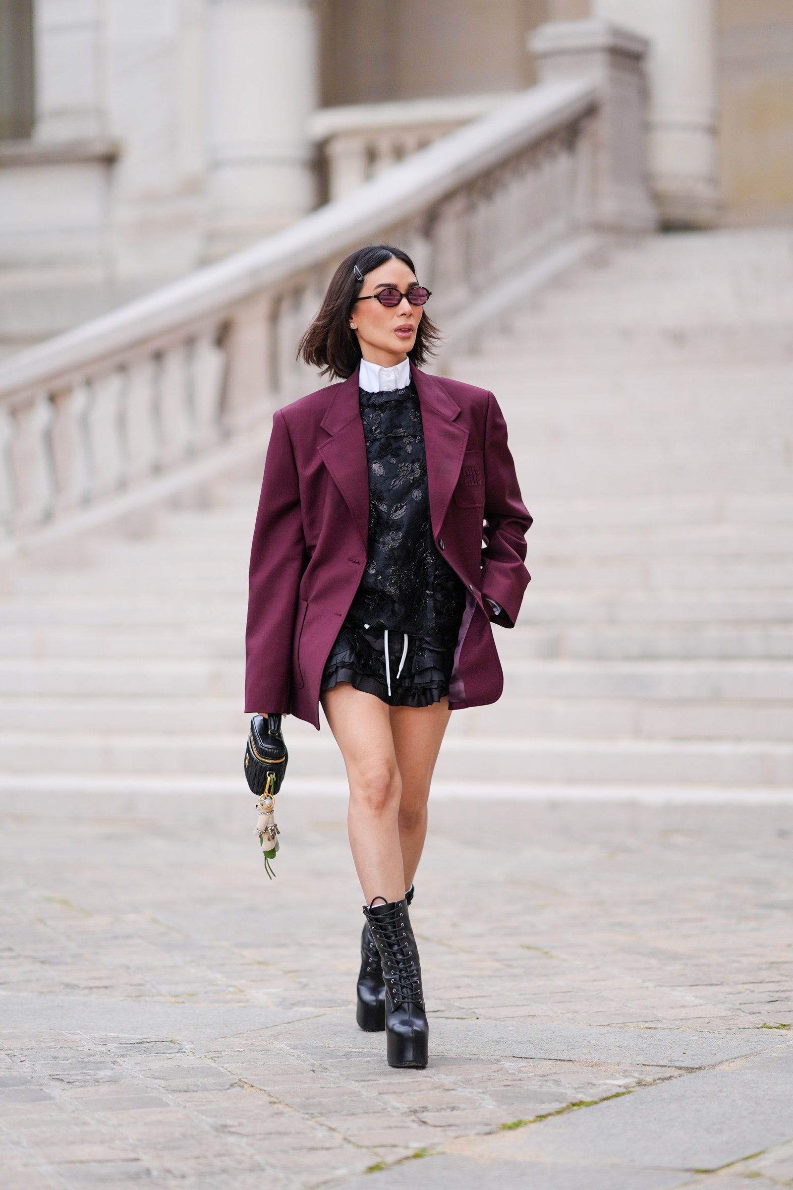 PARIS FRANCE  MARCH 05 Heart Evangelista wears hair pins a white shirt a burgundy oversized blazer jacket  a black...