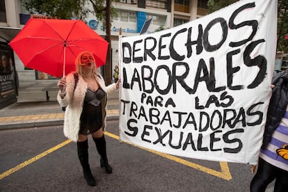 Una mujer junto a un pancarta que pide derechos laborales para las trabajadoras sexuales, en Murcia. 

