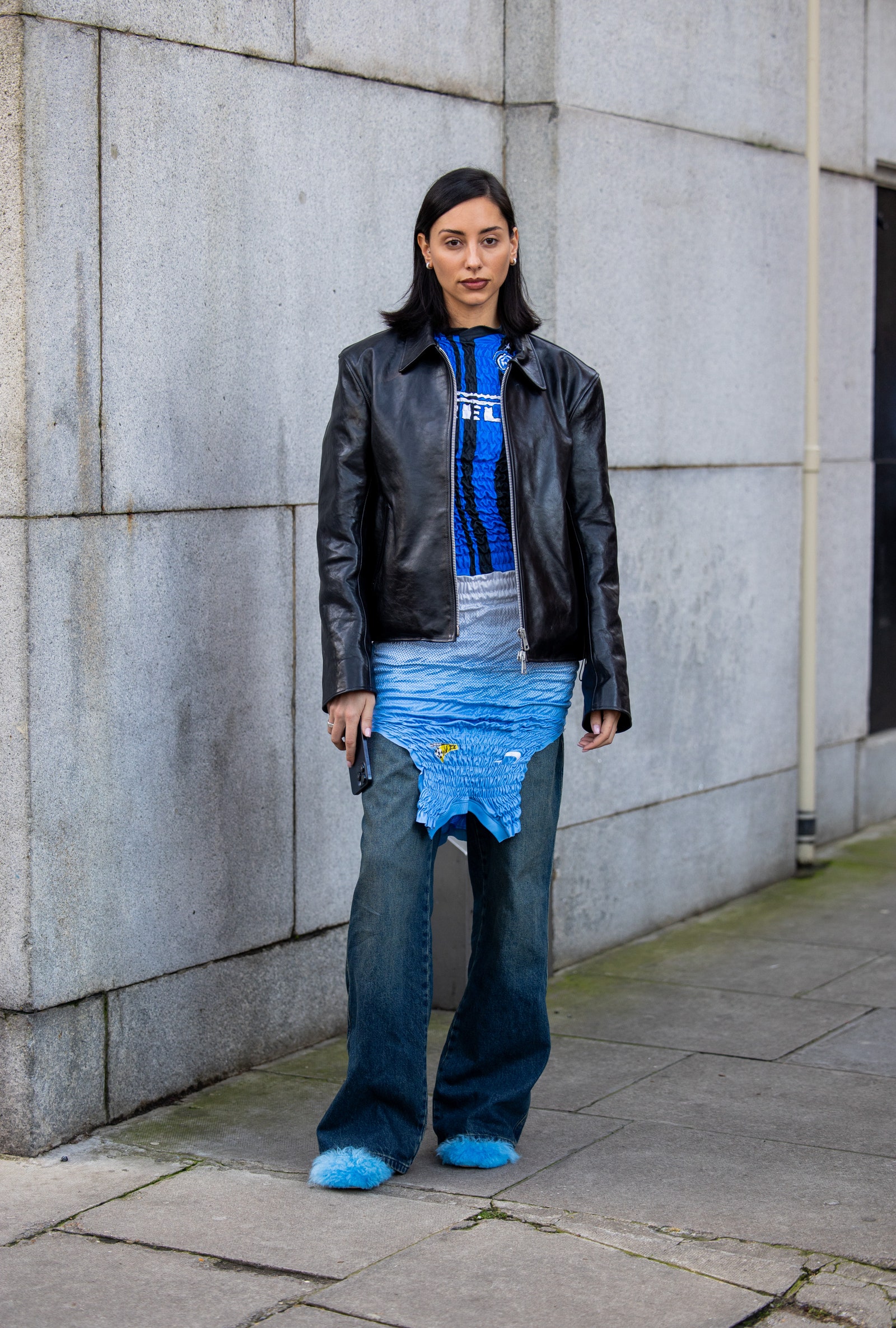 Image may contain Clothing Coat Jacket Pants Jeans Person Electronics Mobile Phone Phone and Standing