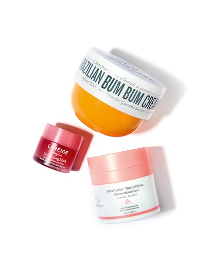 De arriba abajo, tres favoritos de los alfa: hidratante corporal Brazilian Bum Bum Cream de SOL DE JANEIRO, mascarilla nocturna para labios de LANEIGE y crema facial reparadora Bora Barrier de DRUNK ELEPHANT.