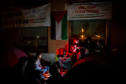 Un alumno toca la guitarra, durante la primera noche de acampada en la Universidad Complutense de Madrid.