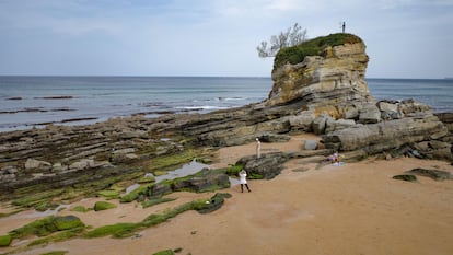 La delicada escultura 'Neptuno niño' en un promontorio de la playa del Camello, en Santander.