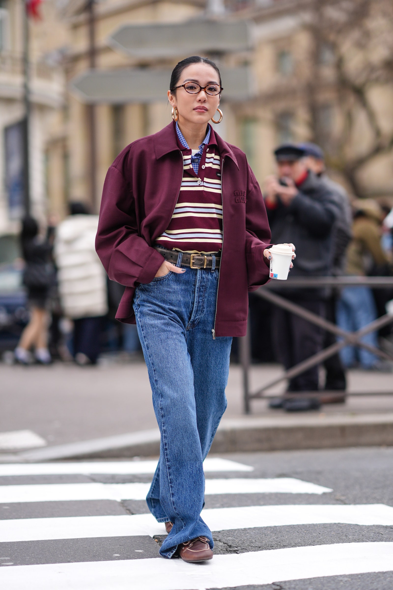 Image may contain Clothing Pants Jeans Pedestrian Person Cup Accessories Belt Glasses Footwear Shoe and Adult