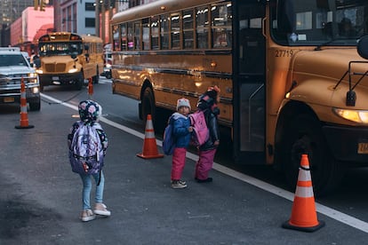 Niños migrantes toman el bus escolar en frente al hotel Row de Nueva York en diciembre de 2023