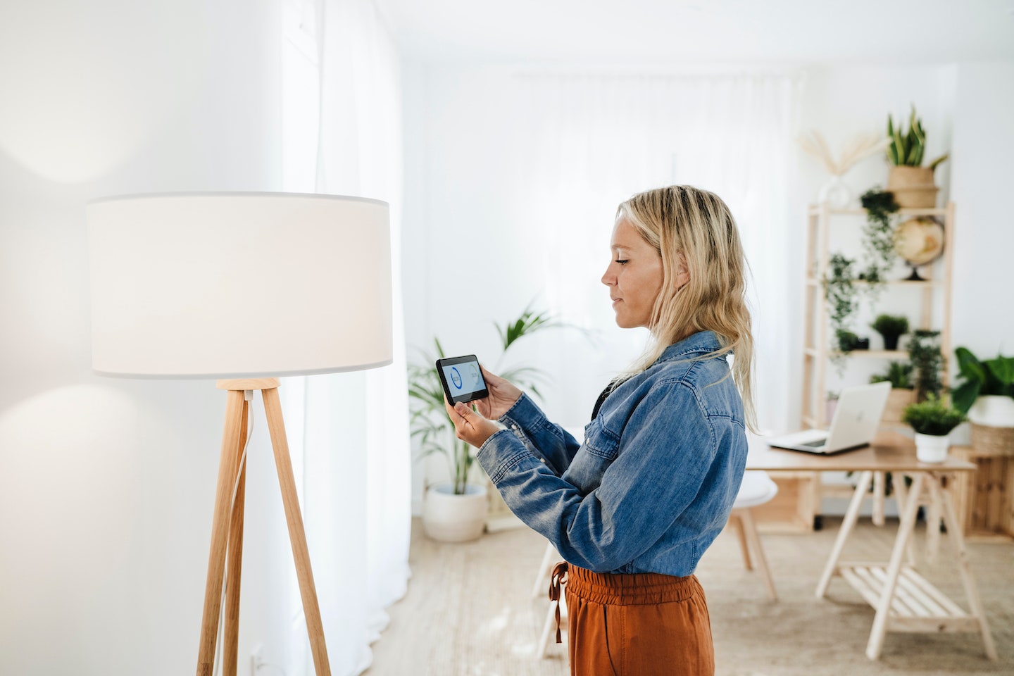 Mujer comprobando el consumo elctrico de una lmpara en casa