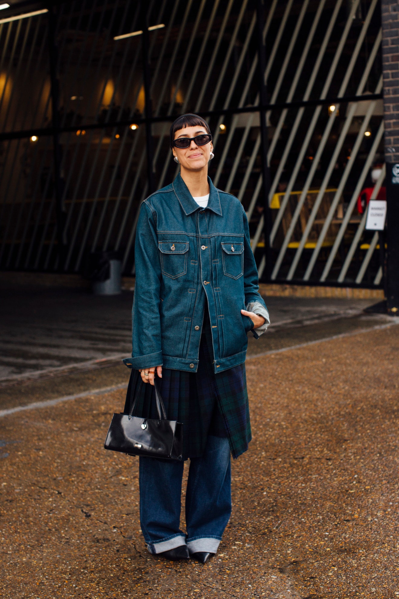 Image may contain Clothing Pants Jeans Coat Accessories Bag Handbag Adult Person Glasses Standing and Footwear