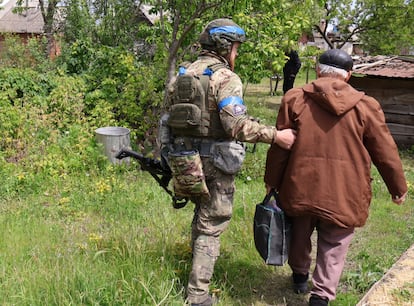 Un policía ucranio ayuda a un anciano a ser evacuado en Vovchansk el 16 de mayo.