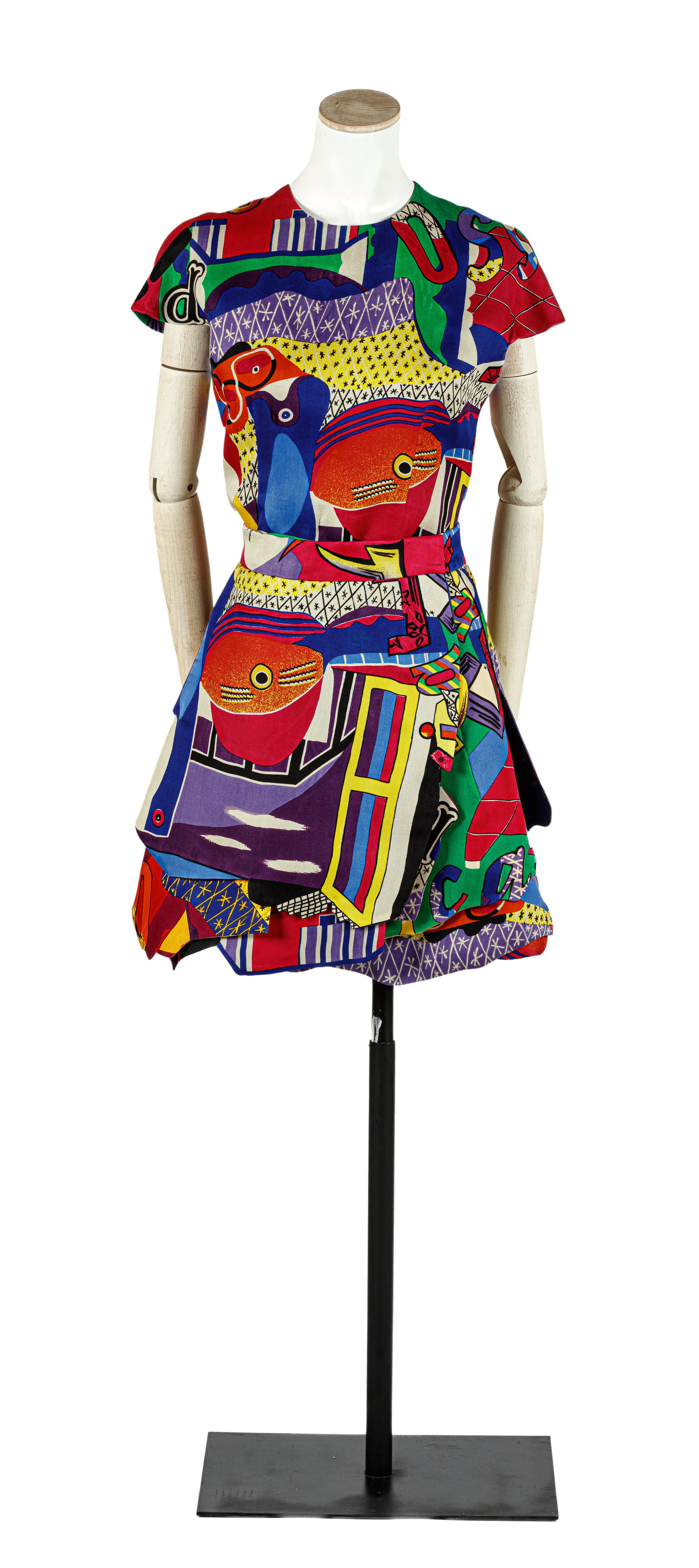 Traje con colores vivos y dibujos geomtricos compuesto de blusa falda y cinturón.