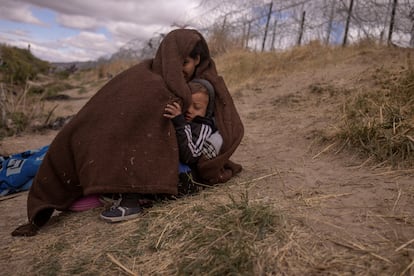 Una madre y su hijo, procedentes de Venezuela, esperan poder cruzar en El Paso (Texas).