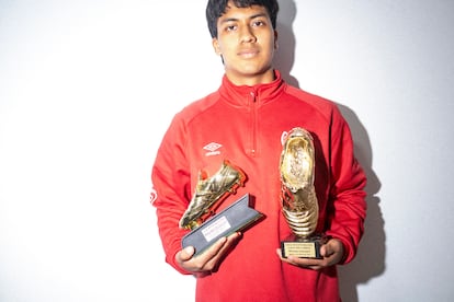 
Dylan posa junto a algunos trofeos de máximo goleador que guarda en su casa. 
