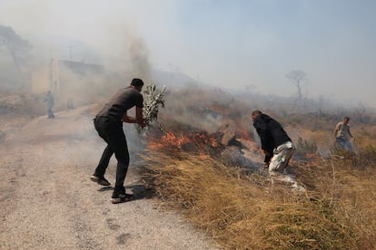 Varios ciudadanos tratan de sofocar un incendio, el pasado 30 de junio en la región de Keratea, cerca de Atenas. 