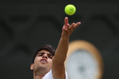 El tenista español Carlos Alcaraz saca la pelota, este domingo en Wimbledon.