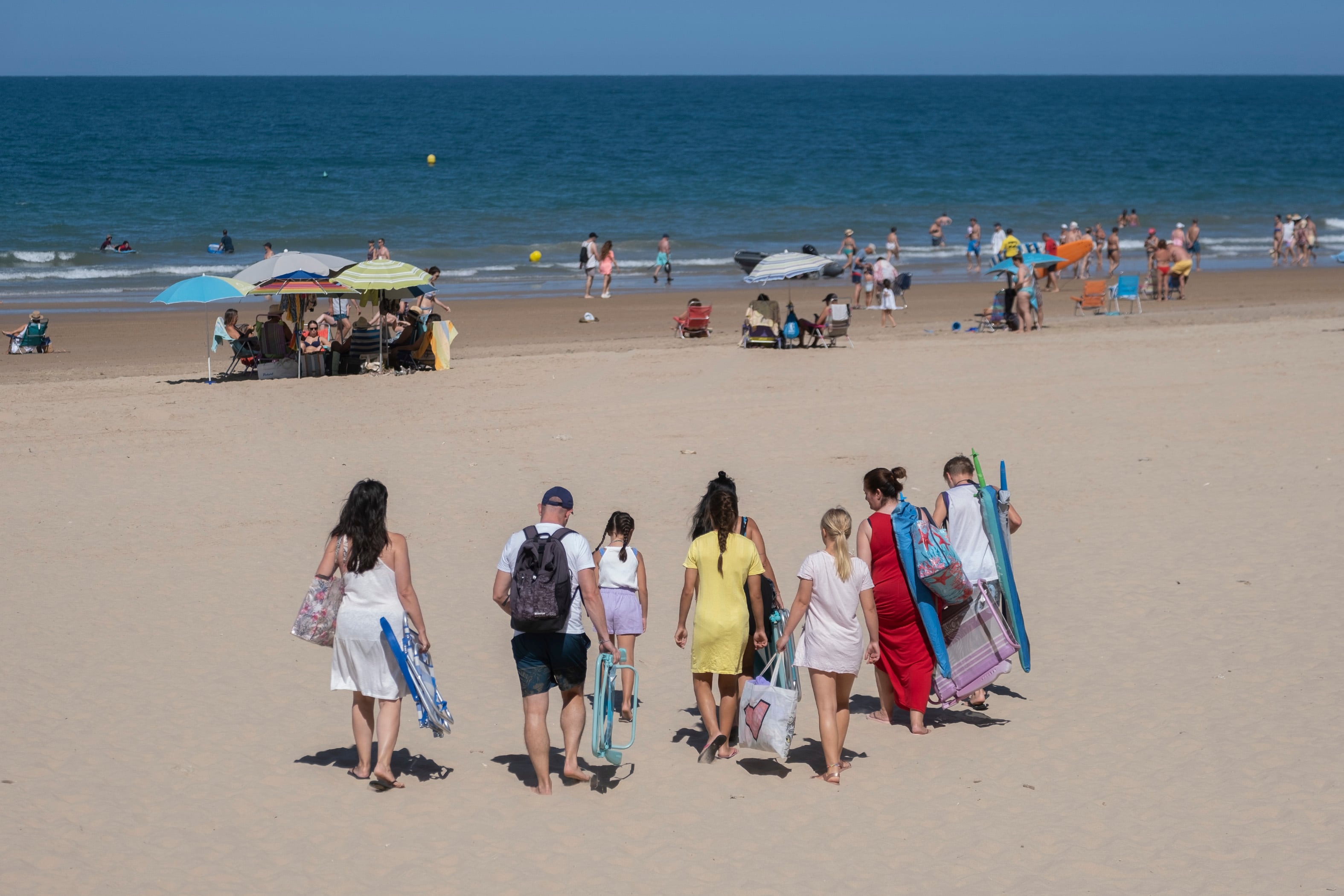 Una familia entra en una playa de Cádiz.