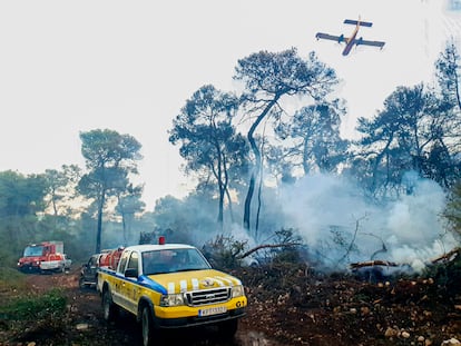 Los vehículos equipados del colectivo anarquista Rouvikonas participan en la extinción de un incendio junto a medios aéreos y terrestres de los bomberos, cerca de Eipdauro, Grecia.
