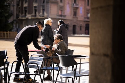 Un camarero atiende a una clienta en Vic (Barcelona), en diciembre de 2023.