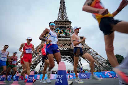 Los atletas pasa junto a la torre Eiffel de París. 