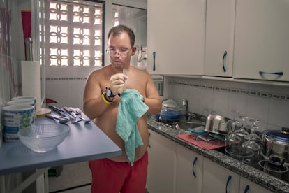 Alejandro limpia los cubiertos en el piso de Isla Cristina, en 2023.