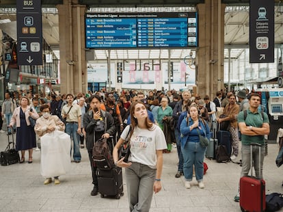 Unos viajeros observan las pantallas de información en la estación del Norte de París. 

