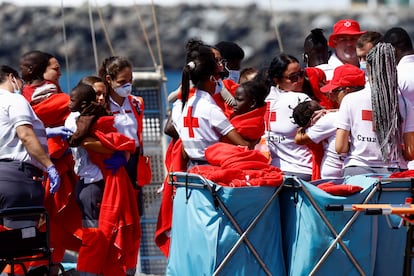 Voluntarios de la Cruz Roja, ayudando a que varios niños desembarquen en el puerto de Arguineguín (Gran Canaria).