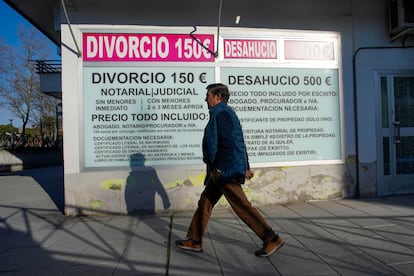 Un hombre pasa por delante de un cartel anunciando trámites de divorcio económicos en Leganés (Madrid). 