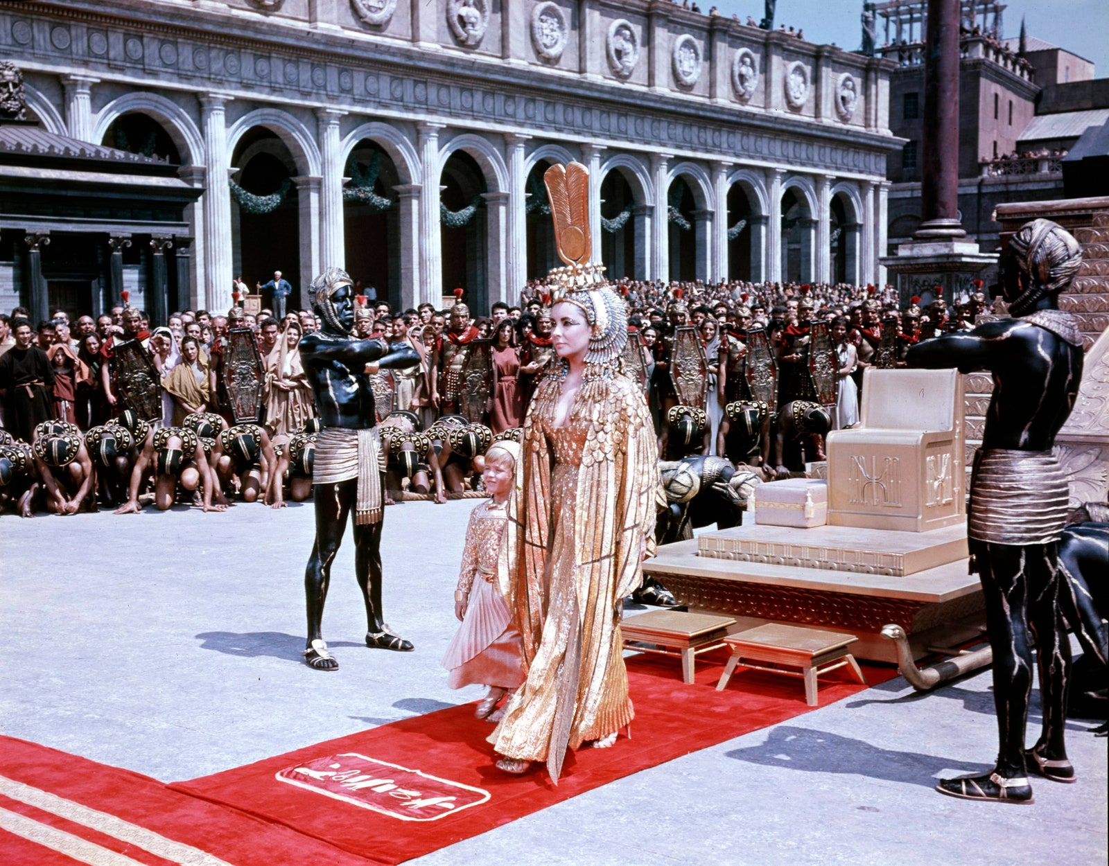 Elizabeth Taylor como una triunfante Cleopatra dorada entrando en Roma .