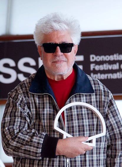 El cineasta manchego Pedro Almódovar sujeta el logotipo del Festival de San Sebastián para la prensa.