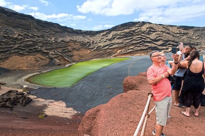 Varios turistas se toman selfis en el Charco Verde de Lanzarote.