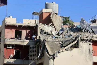 Varias personas inspeccionan un edificio afectado por un ataque israelí en Sidón (Líbano), este domingo.  