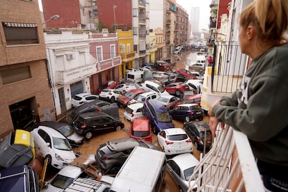 Una mujer mira los daños causados en una decena de vehículos colapsando una calle en Valencia, este miércoles.