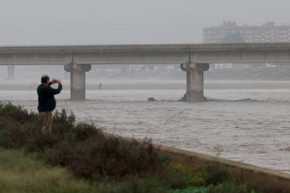 Una persona toma imágenes del cauce del Turia tras las devastadoras inundaciones, este miércoles en Valencia.