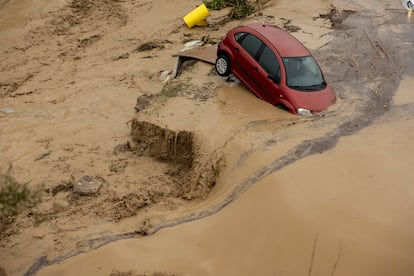 Un coche hundido en la localidad malagueña de Álora tras el desborde del río Guadalhorce, este martes.