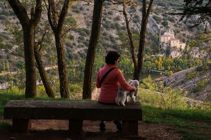 Una paseante descansa en un banco con vistas al Duero y a la ermita de San Saturio, en el entorno del parador de Soria.