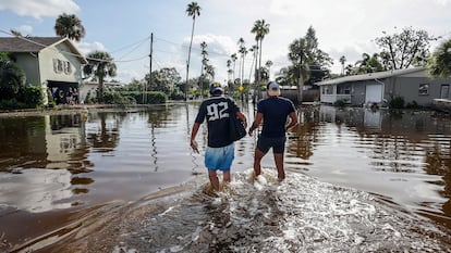 Thomas Chaves y Vinny Almeida caminan a través de las inundaciones provocadas por el huracán Helene en el vecindario de Shore Acres en St. Petersburg, Florida. El viernes 27 de septiembre de 2024. 