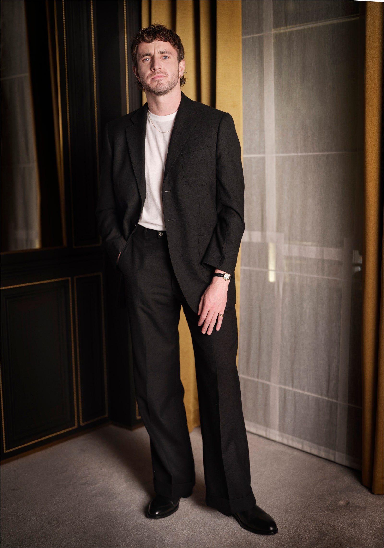 Image may contain Clothing Formal Wear Suit Blazer Coat Jacket Person Standing Adult Wristwatch and Tuxedo