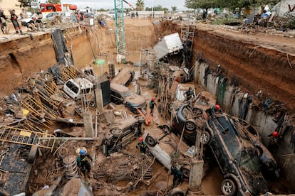 Miembros de la guardia civil buscan cadáveres dentro de los vehículos atrapados entre los cimientos de un edificio en construcción en Paiporta (Valencia), este sábado.