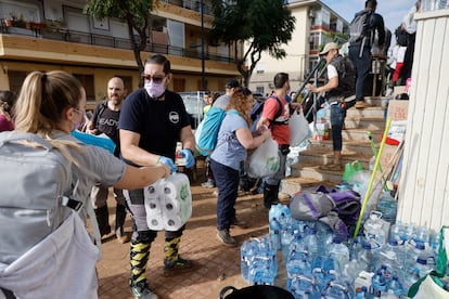 Reparto de agua y otros enseres en un punto de distribución en la localidad de Alfafar, este sábado.