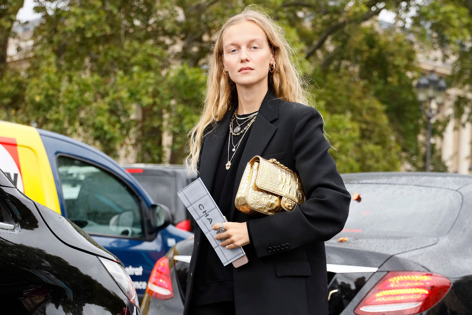 Estilismo con blazer negro y botas y bolso dorado