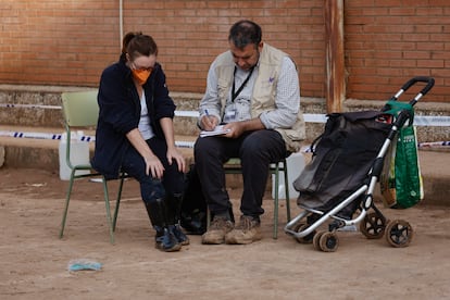 Un voluntario de Psicólogas y Psicólogos Sin Fronteras junto a una ciudadana en un instituto de la localidad valenciana de Sedaví convertido en un centro de Atención Ciudadana este martes.