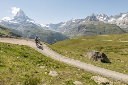 Una ciclista recorriendo las montañas de Valais (Suiza), con el monte Cervino (Matterhorn) al fondo de la imagen.