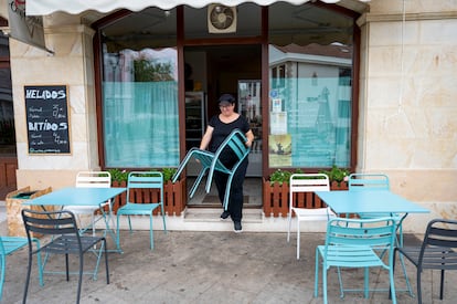 Una mujer prepara una terraza, el 26 de julio en Puente San Miguel (Cantabria).