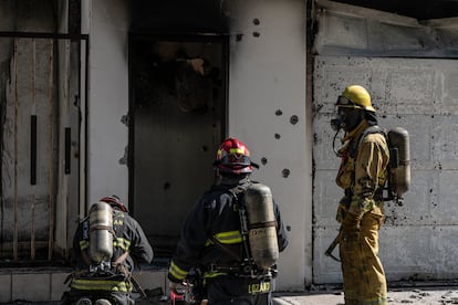 Bomberos apagan el fuego de una casa que fue atacada a balazos y quemada en Culiacán el 25 de noviembre.