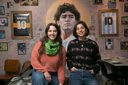 Natalia Eili (i) y Belén Alfonso (d), militantes de 'Argentinxs en Movimiento', frente a un mural de Diego Maradona, el 12 de noviembre. 