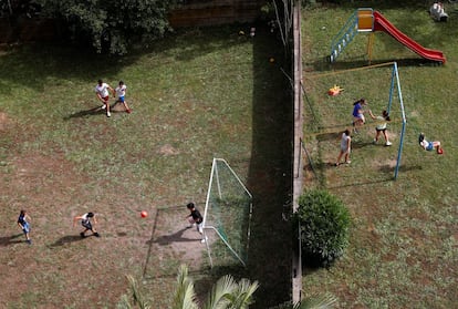 Vista aérea de unos niños jugando al fútbol mientras unas niñas juegan en los columpios, en Roma (Italia).