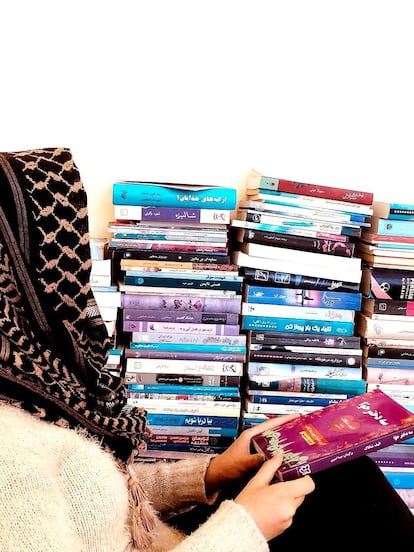 Noor sostiene un libro traducido al persa de Elif Shafak titulado 'Las tres hijas de Eva', en Herat, Afganistán, en 2024. Fotografía cortesía de su hermana.