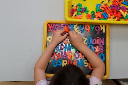 Un niño juega con letras magnéticas durante una clase en un colegio de Madrid.