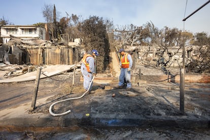 Trabajadores de la compañía de gas cierran válvulas y llaves de paso de viviendas en la zona quemada en Sunset Boulevard, a la altura de Pacific Palisades, en Los Ángeles. 