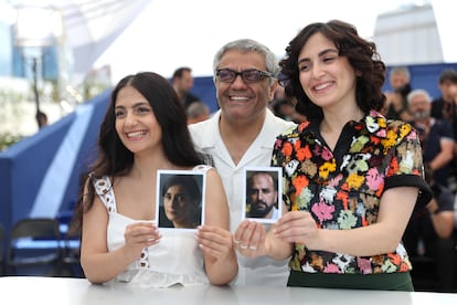 Mahsa Rostami (derecha) y Setareh Maleki (izquierda) sujetan fotos de sus compañeros de reparto, y padres en el filme, Missagh Zareh y Soheila Golestani, junto a Mohammad Rasoulof en la presentación en Cannes el pasado mayo de 'La semilla de la higuera sagrada'.
