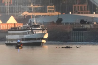 Un ferry que participa en las tareas de emergencia junto al helicóptero del accidente, este jueves.