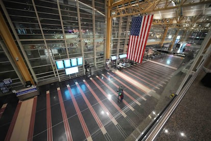 Varias personas caminan por el Aeropuerto Nacional Ronald Reagan de Washington, prácticamente vacío, el jueves.