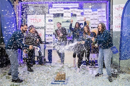 El lotero Víctor Fernández celebra este lunes con cava junto a sus empleadas el haber vendido una serie del segundo premio del sorteo extraordinario de El Niño, el número 06766, en la administración del centro comercial de Las Arenas en Barcelona.